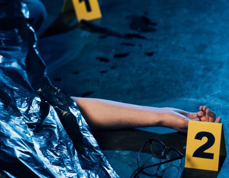 partial view of covered corpse with glasses at crime scene