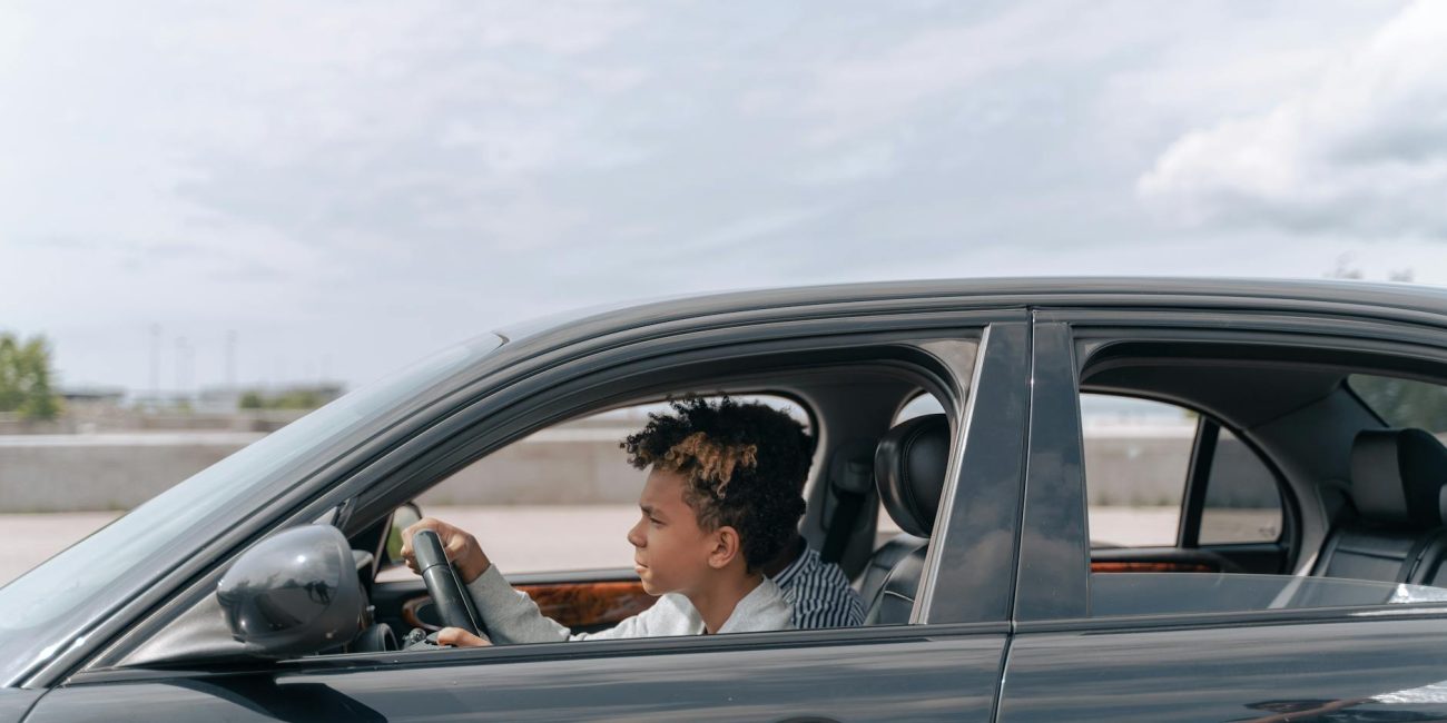 man in brown jacket driving car