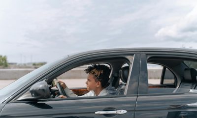 man in brown jacket driving car