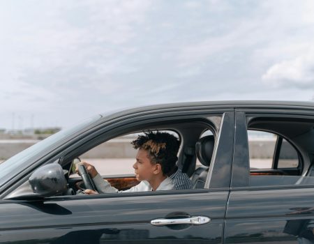 man in brown jacket driving car