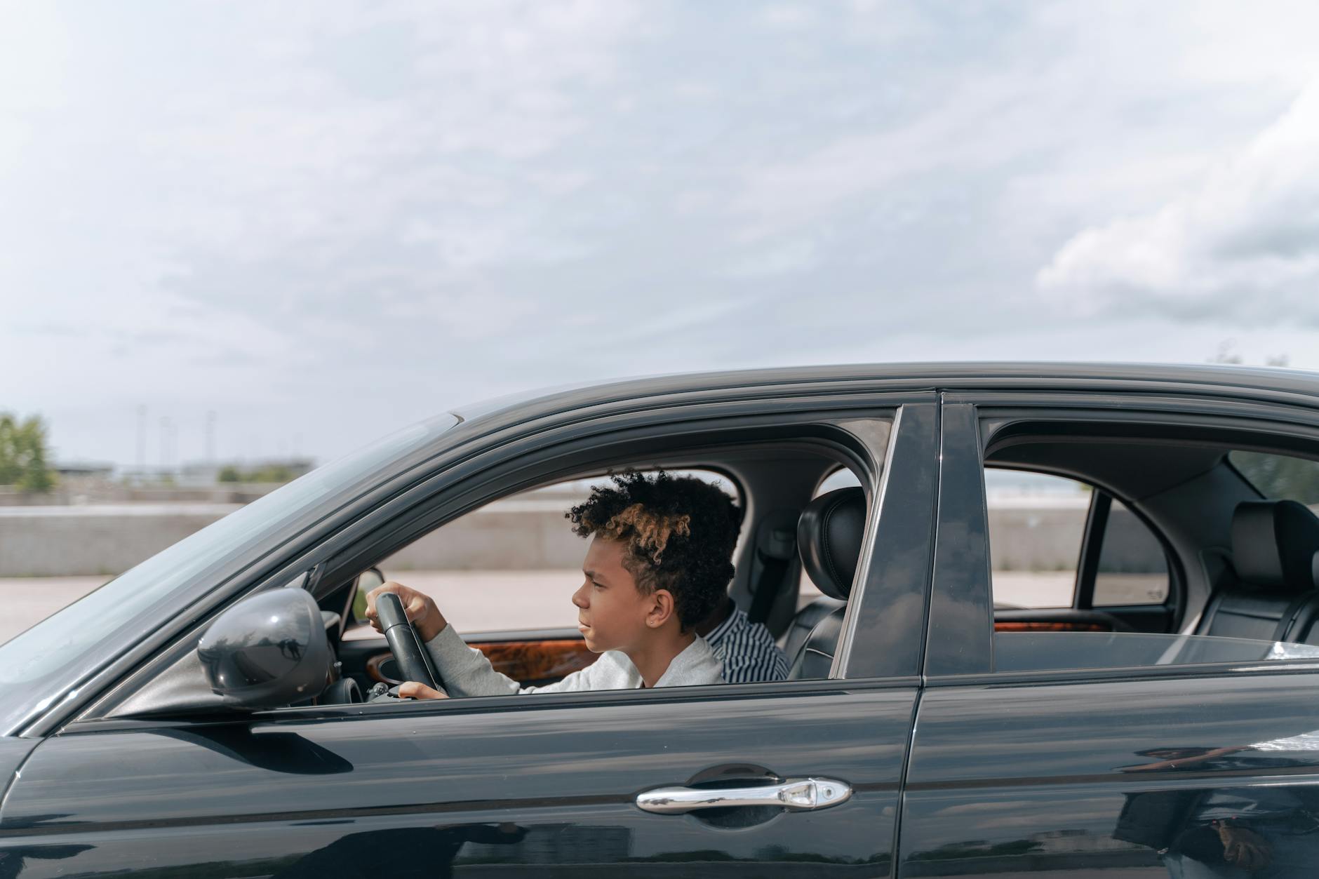 man in brown jacket driving car