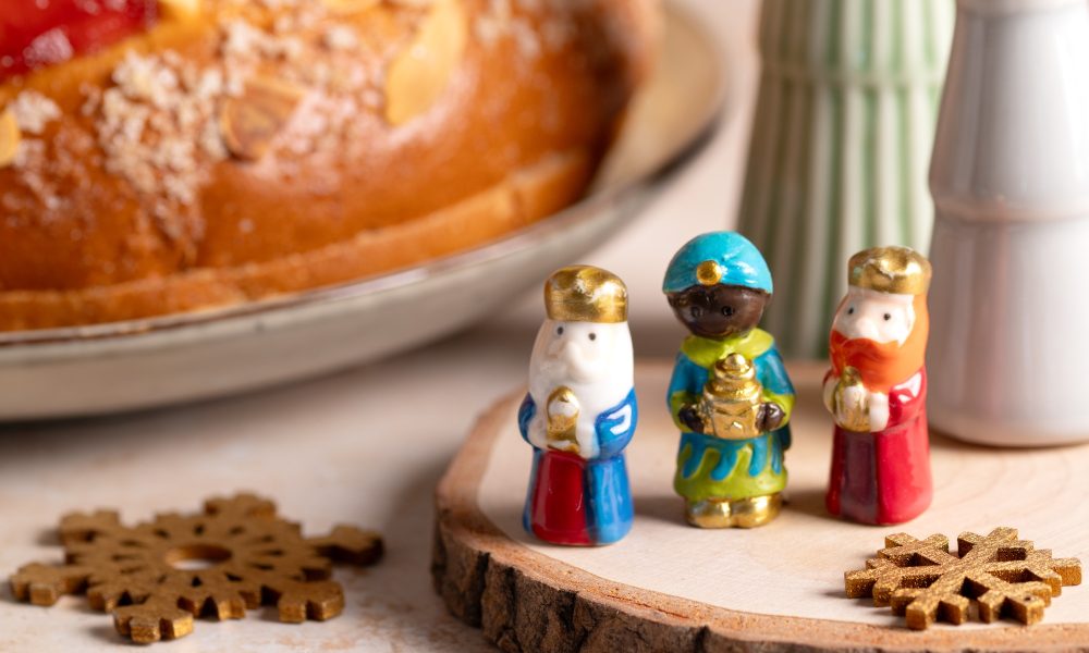 Card with traditional Three Kings Cake, three figurines of the kings in front