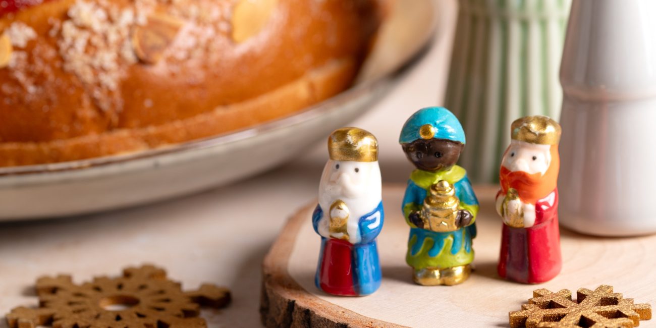 Card with traditional Three Kings Cake, three figurines of the kings in front