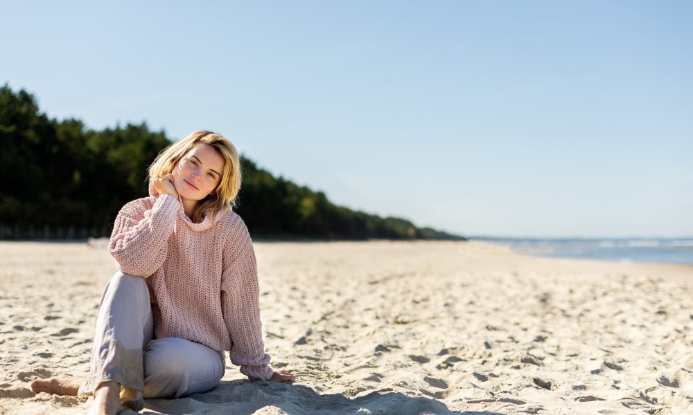 Happy woman on beach during cold spring weather