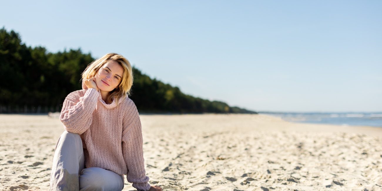 Happy woman on beach during cold spring weather