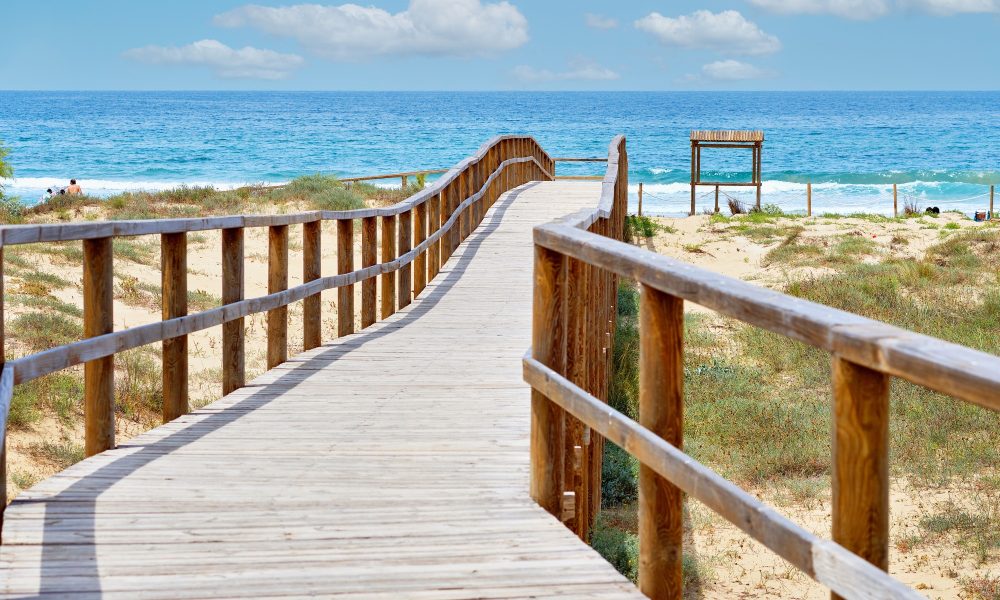 Wooden empty board walk leading to Mediterranean Sea and beach of Los Arenales Arenals del Sol Spain