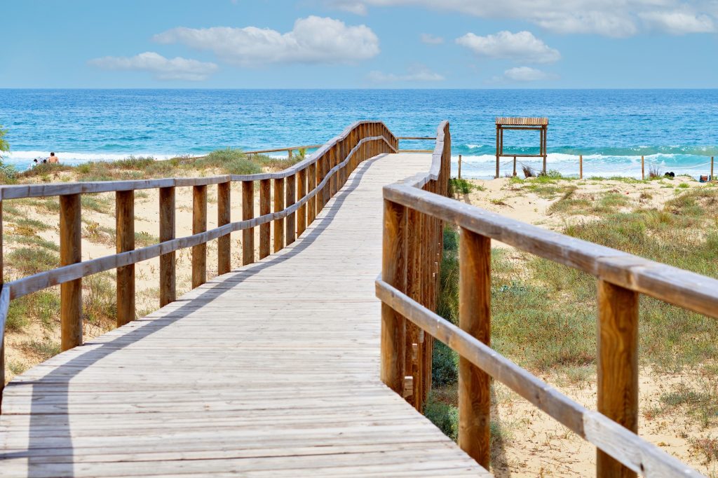 Wooden empty board walk leading to Mediterranean Sea and beach of Los Arenales Arenals del Sol Spain