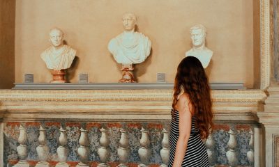 Young woman walking in the museum, sculptures, travel and tourism, travel destinations, from behind