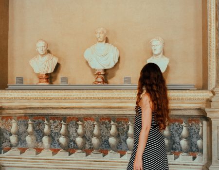 Young woman walking in the museum, sculptures, travel and tourism, travel destinations, from behind