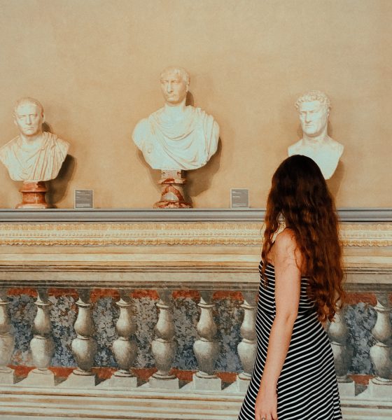 Young woman walking in the museum, sculptures, travel and tourism, travel destinations, from behind