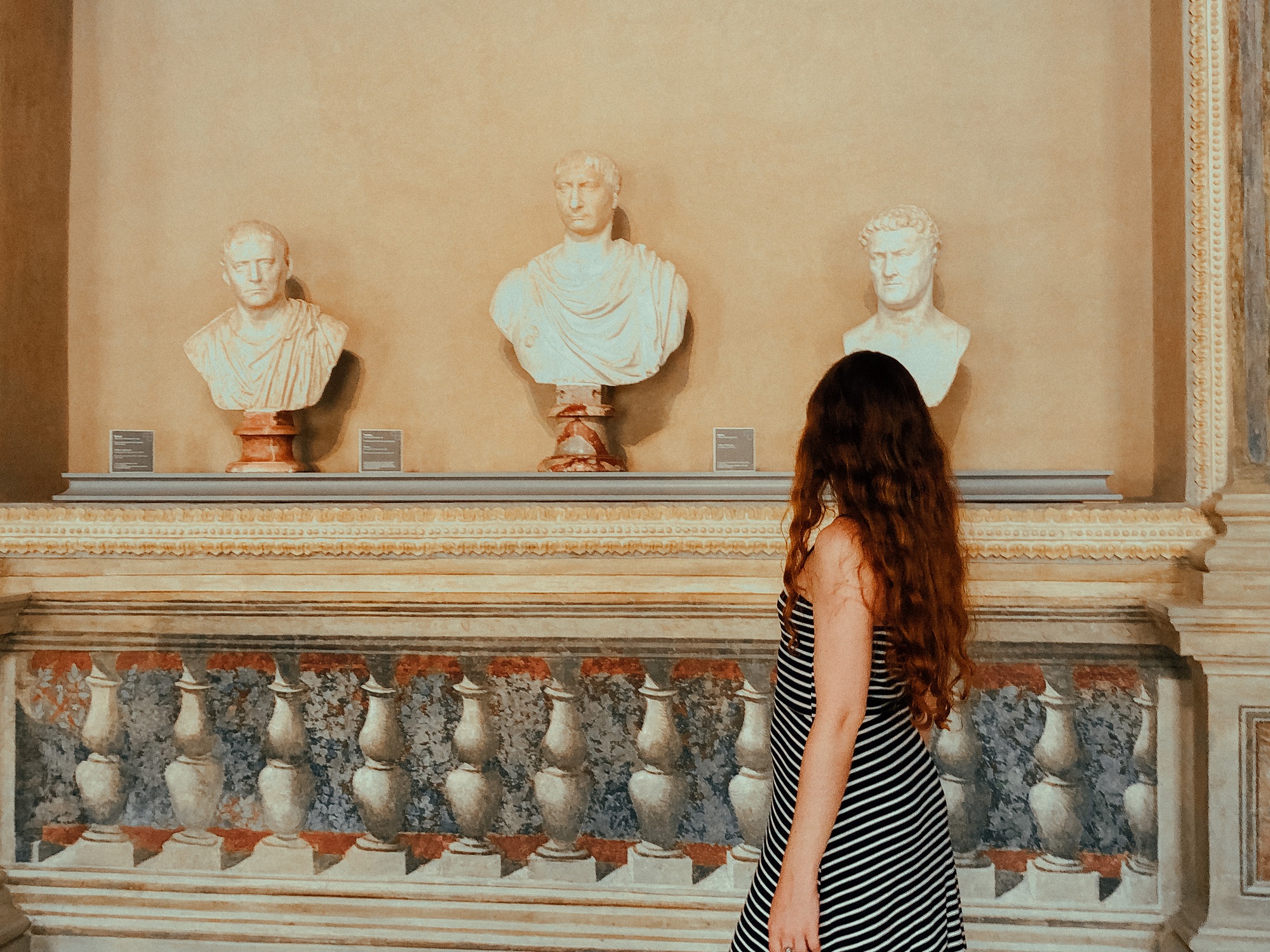 Young woman walking in the museum, sculptures, travel and tourism, travel destinations, from behind