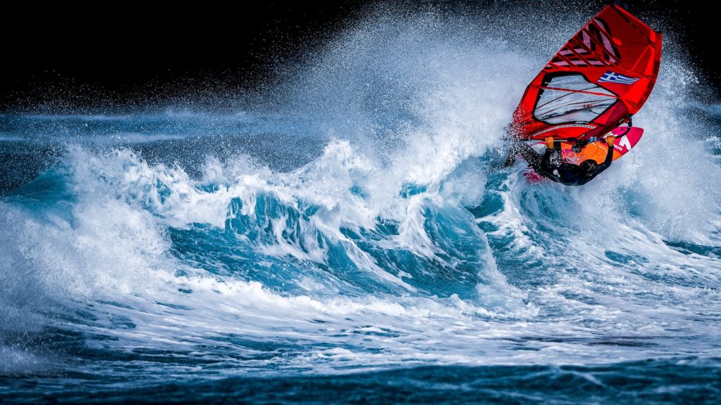 Dynamic windsurfing scene with vibrant colors and thrilling motion on ocean waves.