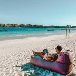 a man sitting on a bean bag on the beach