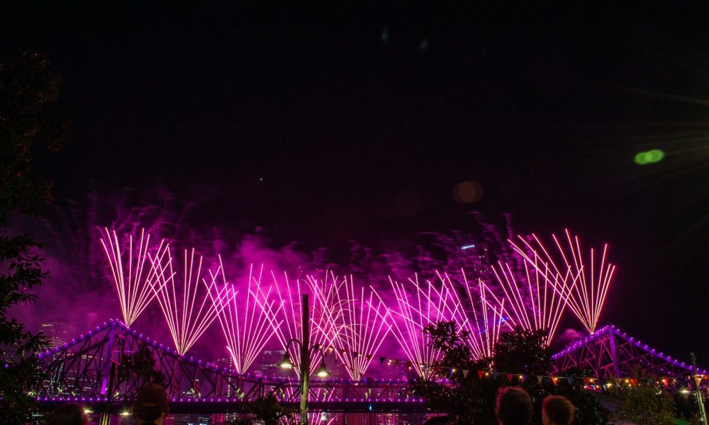 a group of people watching fireworks on a bridge