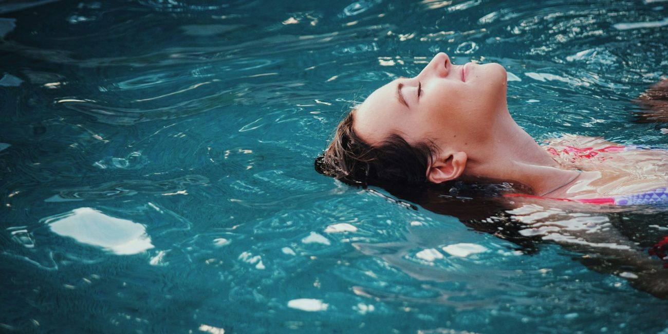 woman floating on body of water