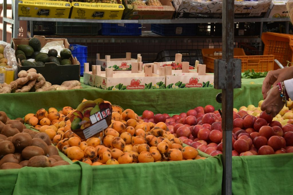 a man standing in front of a display of fruits