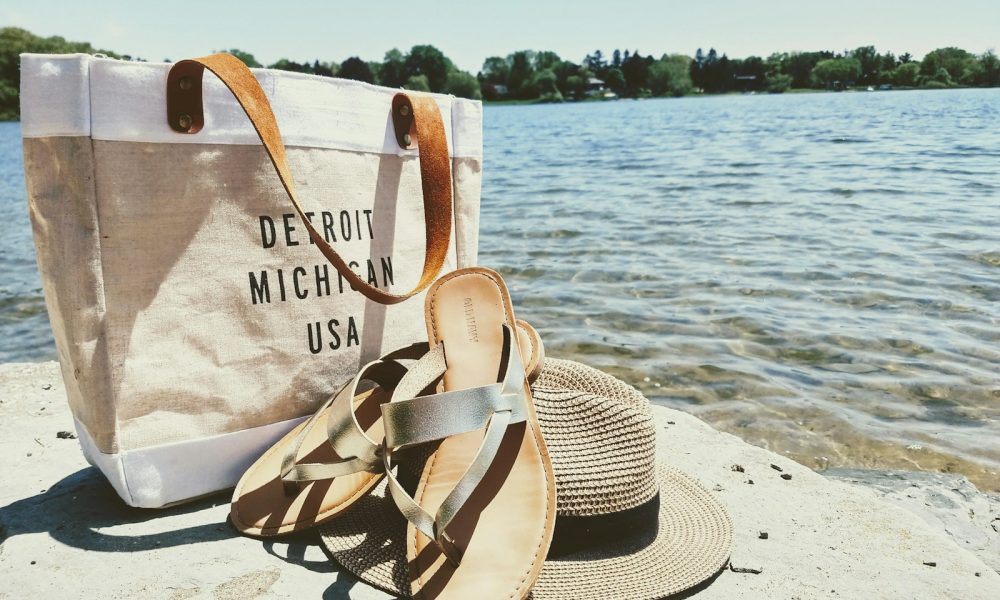hat, sandals, and bag near water