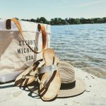 hat, sandals, and bag near water