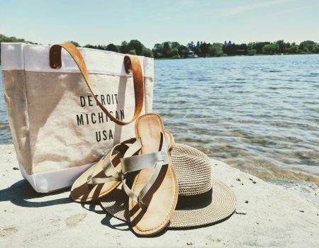 hat, sandals, and bag near water