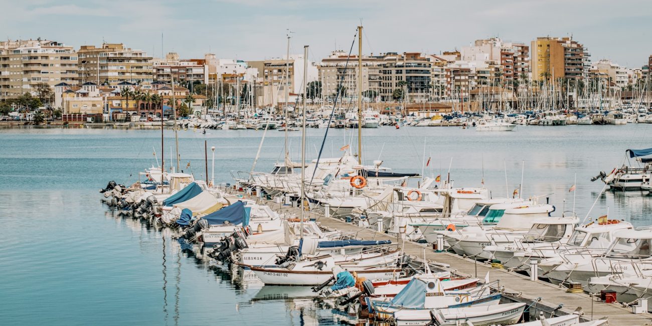 white and blue boats on dock during daytime