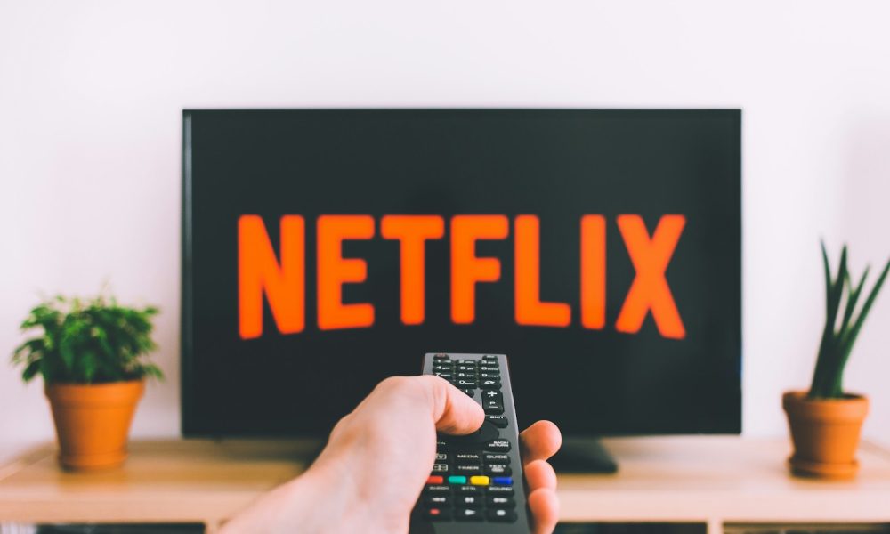 person holding remote pointing at TV