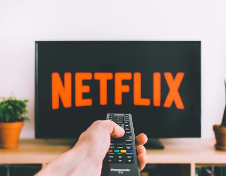 person holding remote pointing at TV