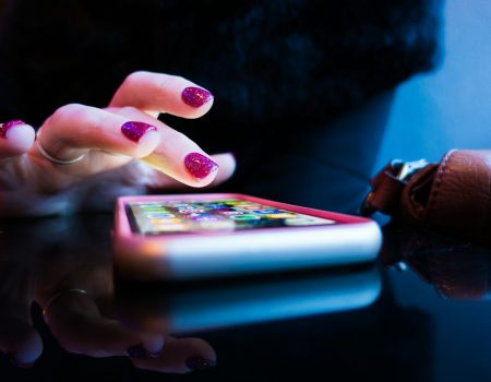 person using black smartphone with gray and pink case