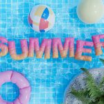 a pool with a pool float, inflatable toys, and the word summer