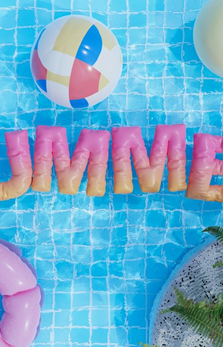 a pool with a pool float, inflatable toys, and the word summer