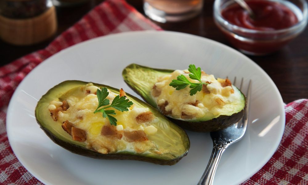 a white plate topped with two stuffed avocados