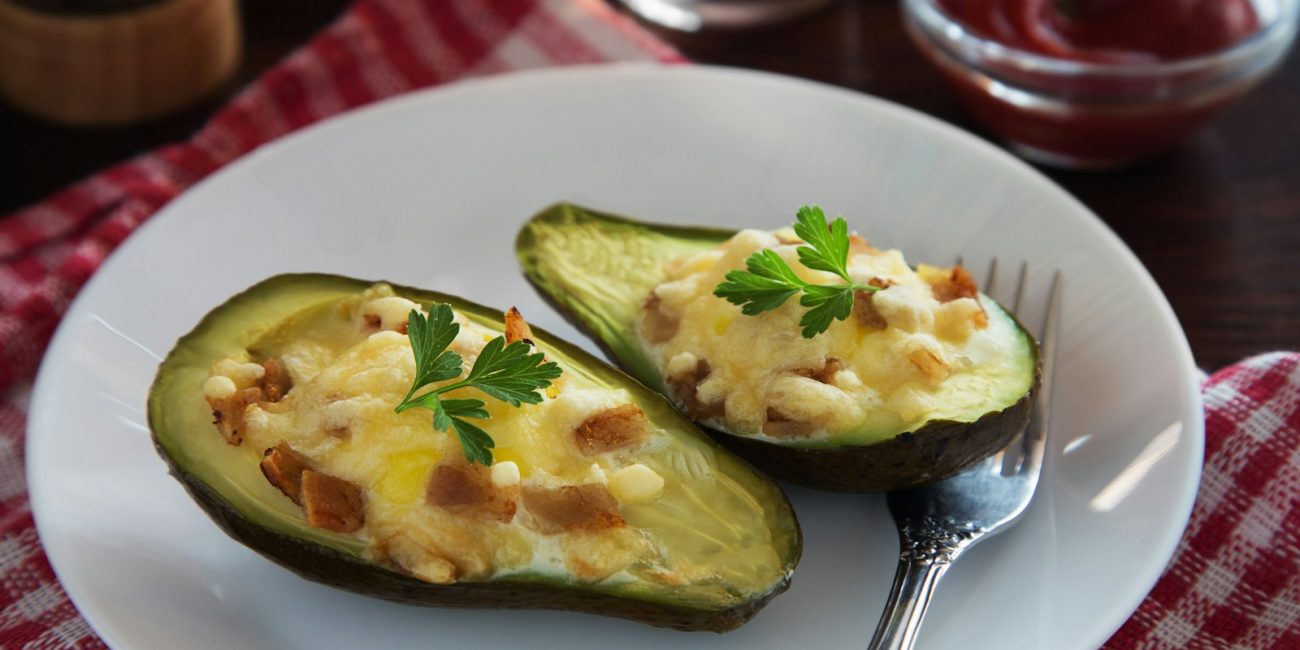a white plate topped with two stuffed avocados