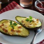 a white plate topped with two stuffed avocados