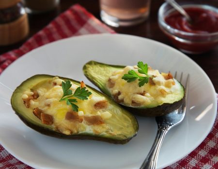 a white plate topped with two stuffed avocados