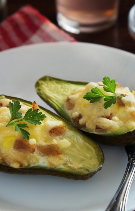 a white plate topped with two stuffed avocados