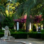 white statue of man and woman near green trees during daytime