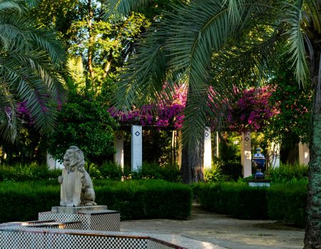 white statue of man and woman near green trees during daytime