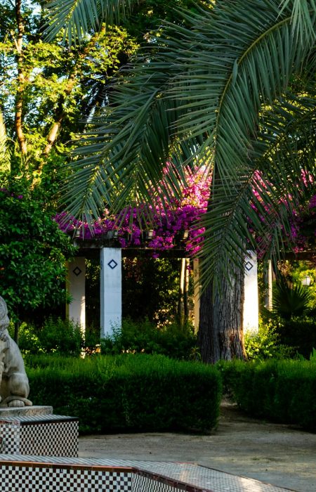 white statue of man and woman near green trees during daytime