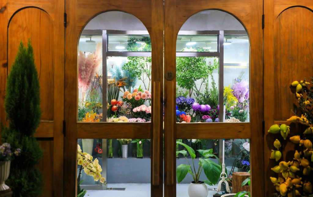 A floral shop is seen through wooden doors.