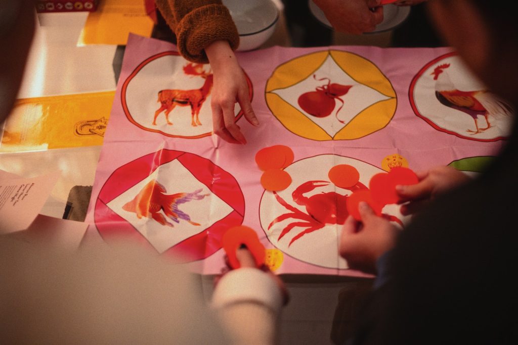 People are crafting paper animals on a table.