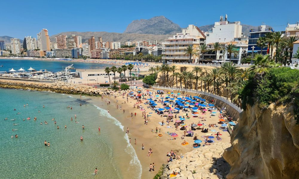 a beach with people and buildings by it