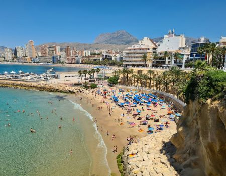 a beach with people and buildings by it