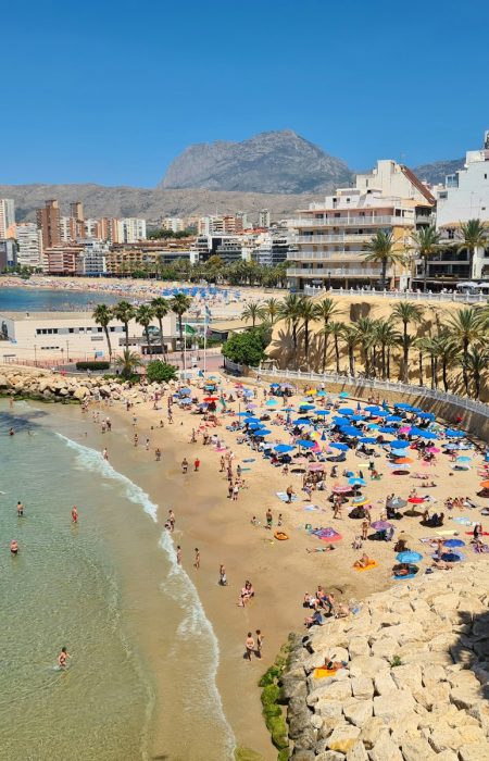 a beach with people and buildings by it