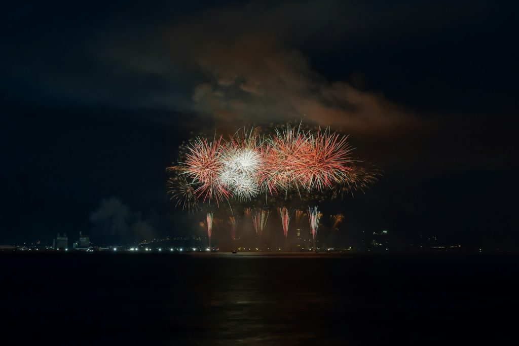 Fireworks light up the night sky above water.