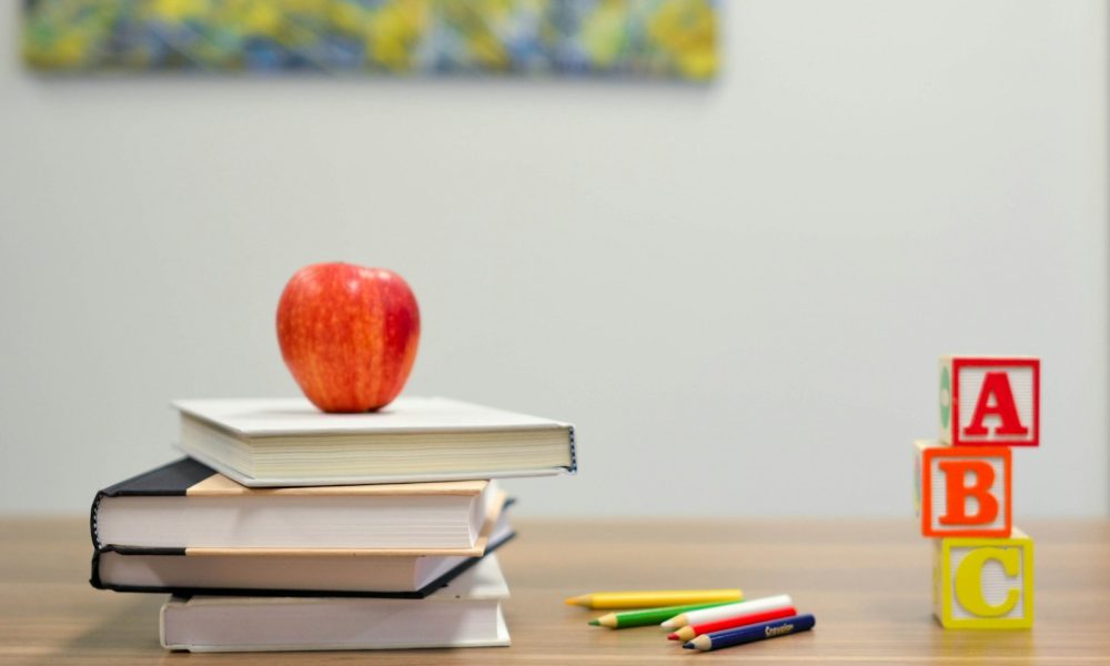 red apple fruit on four pyle books
