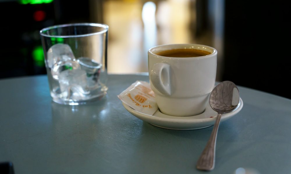 A cup of coffee and a spoon on a table