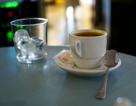 A cup of coffee and a spoon on a table