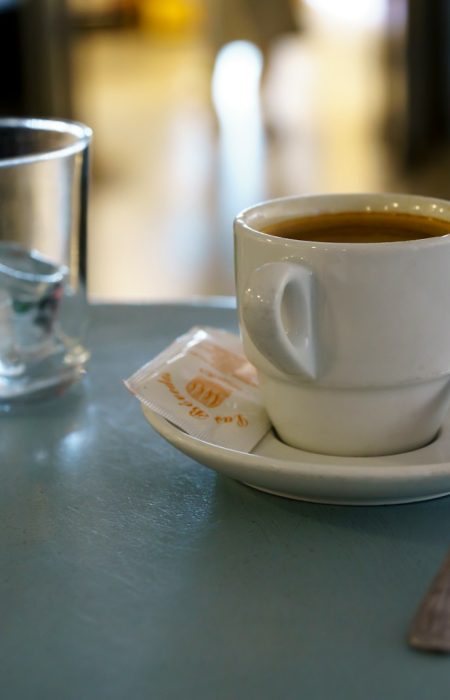 A cup of coffee and a spoon on a table