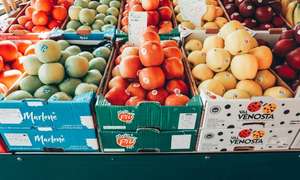 a fruit stand with apples, oranges, apples, and pears