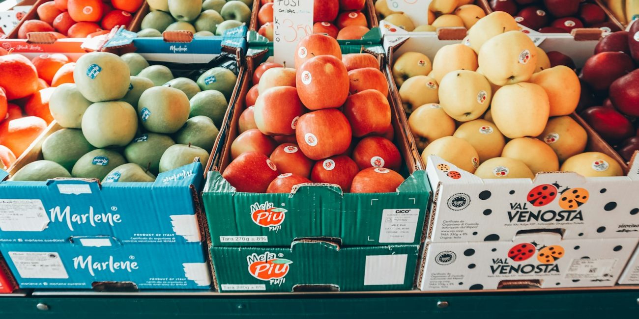 a fruit stand with apples, oranges, apples, and pears