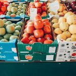 a fruit stand with apples, oranges, apples, and pears